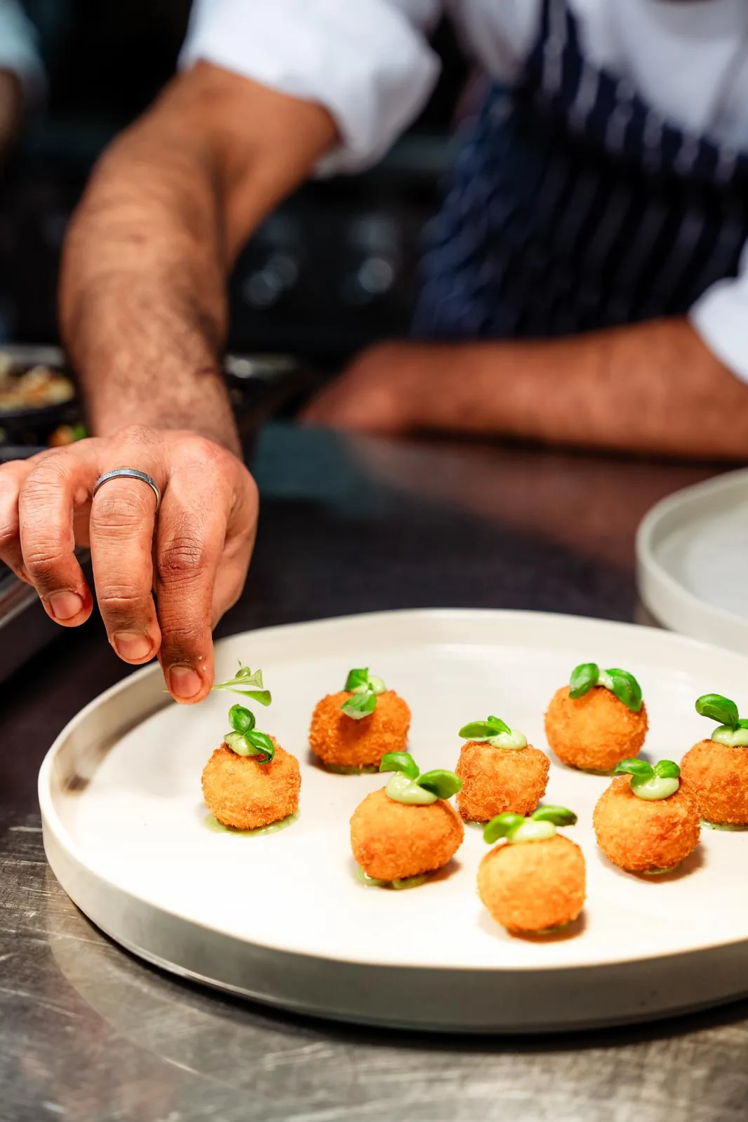 Chef adding final details to a plated tasting-menu course