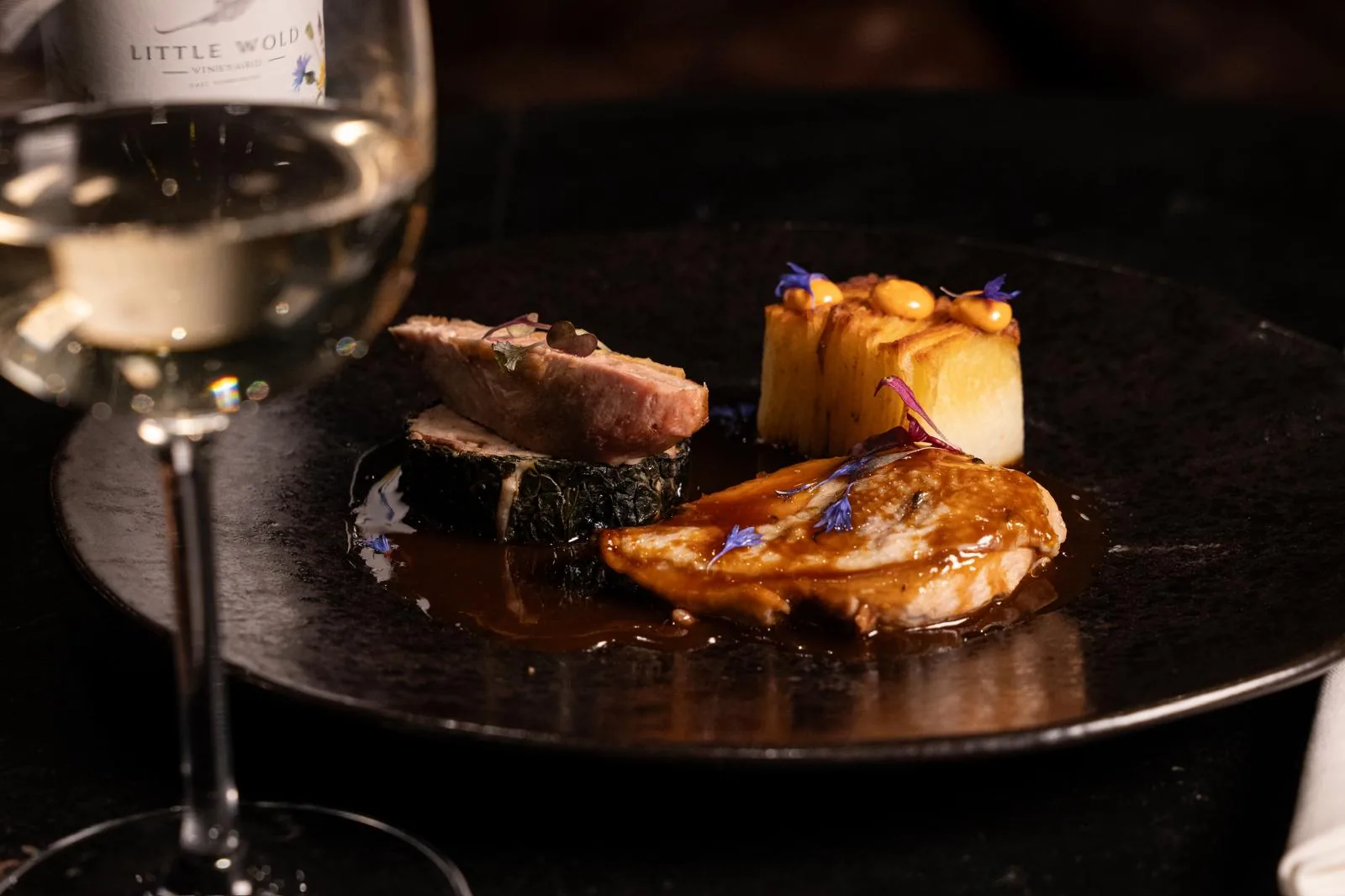 Savoury tasting-menu course served with wine