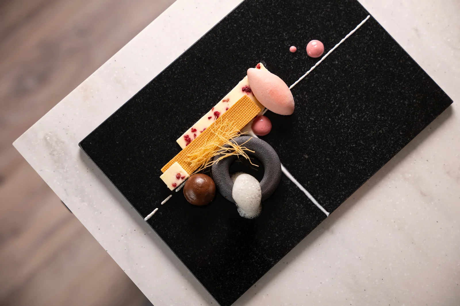 Fine dining pastry course with chocolate, fruit and delicate garnishes
