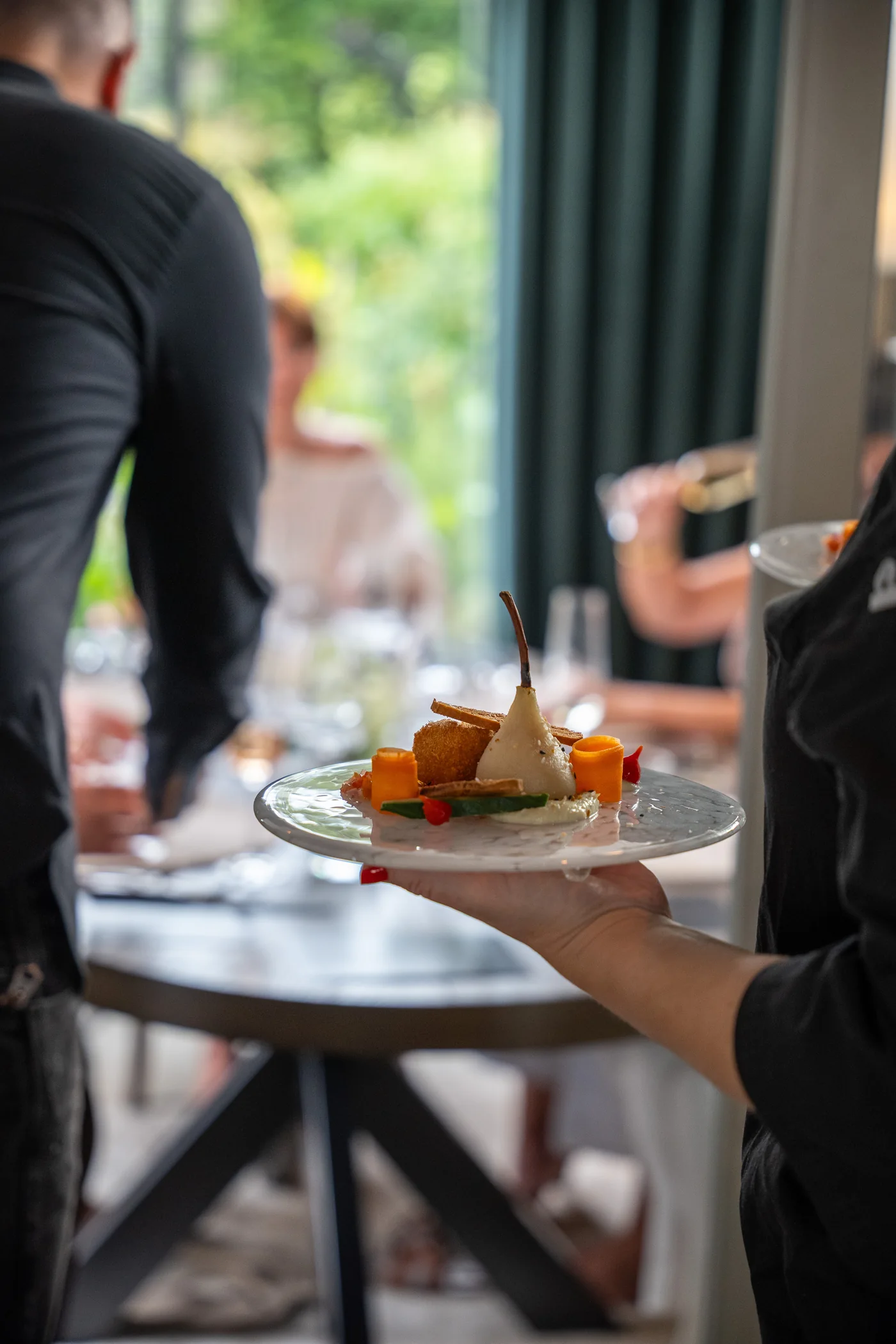 Camila Ramaciotti serving a plated course at the table